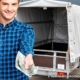 Persoon in blauw geruit shirt overhandigt geld om aanhangwagen te kopen