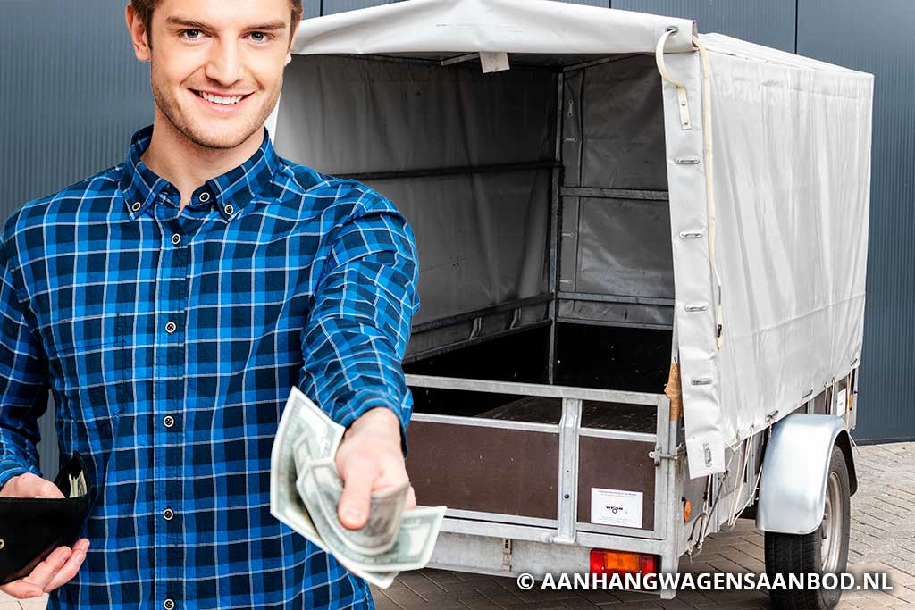 Persoon in blauw geruit shirt overhandigt geld om aanhangwagen te kopen
